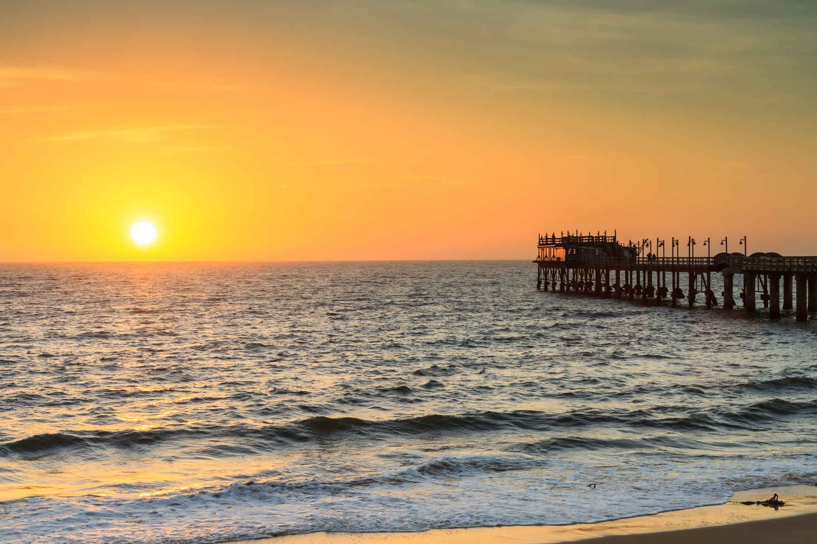 Die Jetty von Swakopmund im Gegenlicht, die Sonne steht tief über dem Atlantik