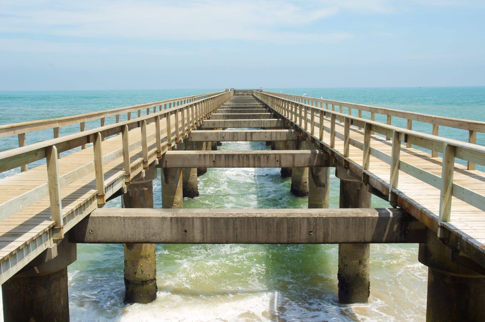 Blick längs über die Holzplanken der Jetty von Swakopmund hinaus aufs Meer